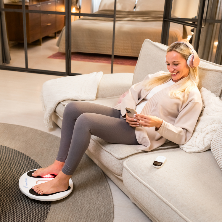 Venen Engel: Mood Bild Frau in beiger Homewear auf Sofa mit EMS Venen Board