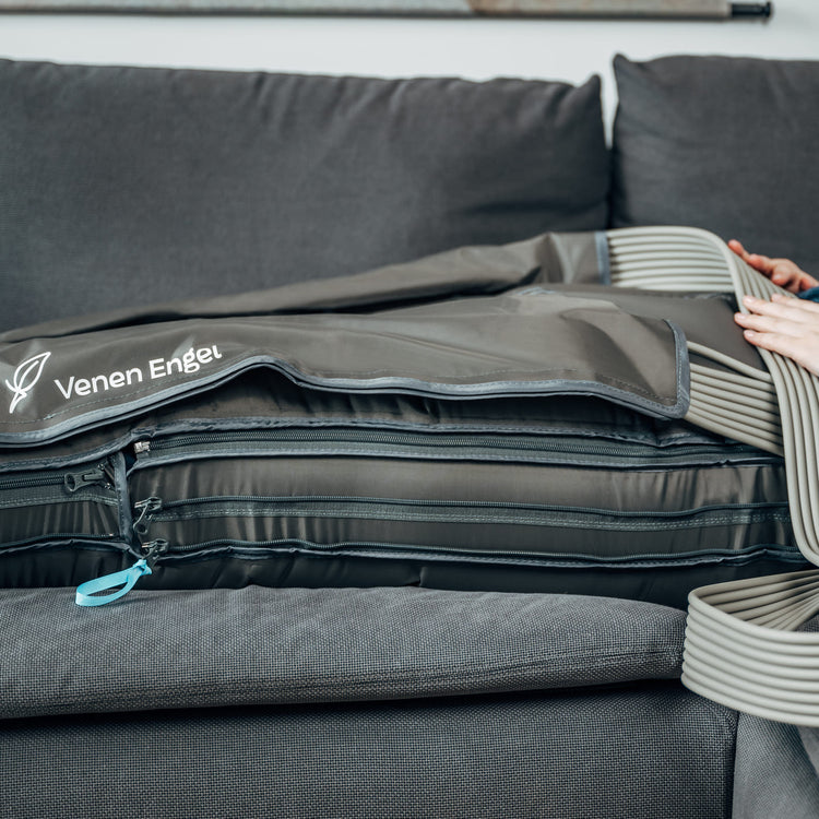 Venen Engel: Detailaufnahme beine auf Sofa mit Kompressionsmassagegerät