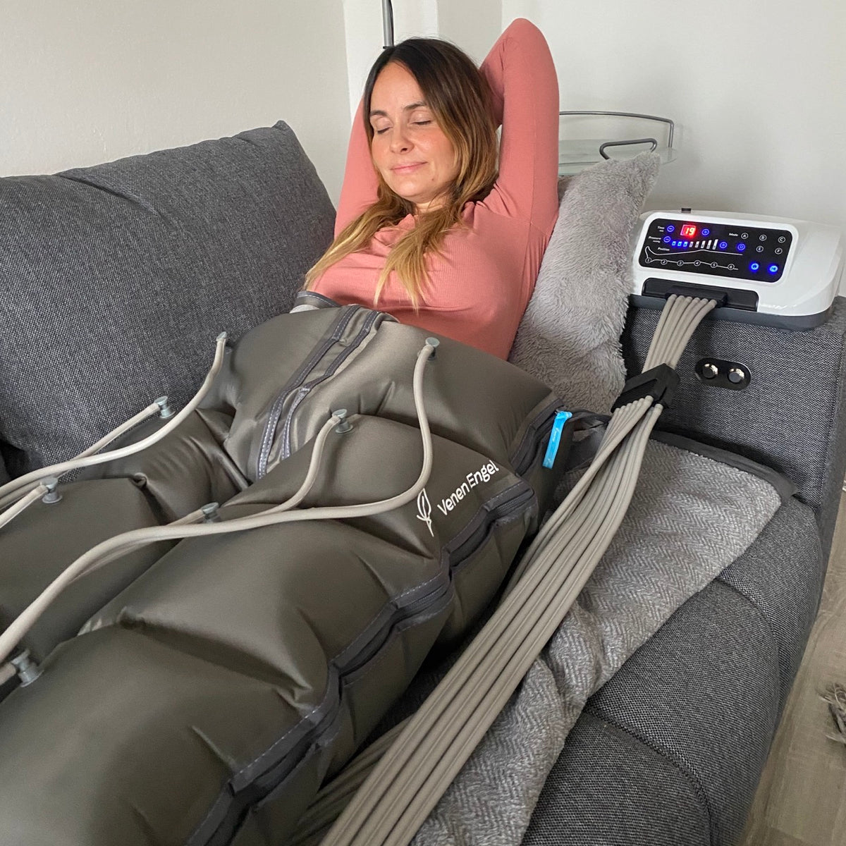 Venen Engel: thea thomas auf Sofa entspannt mit Hosenmanschette und Kompressionsmassagegerät