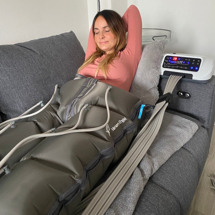 Venen Engel: thea thomas auf Sofa entspannt mit Hosenmanschette und Kompressionsmassagegerät