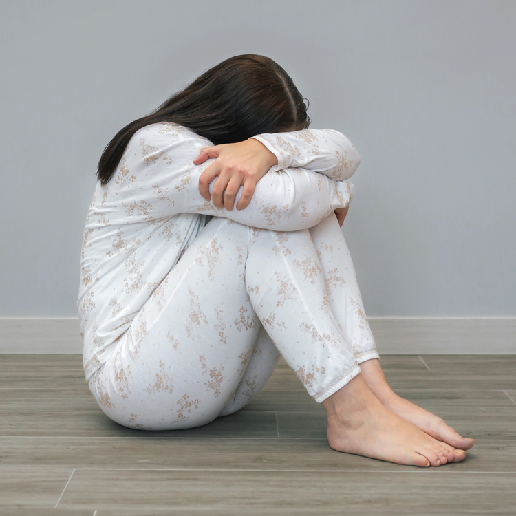 Venen Engel: sitzende Frau vor grauer Wand